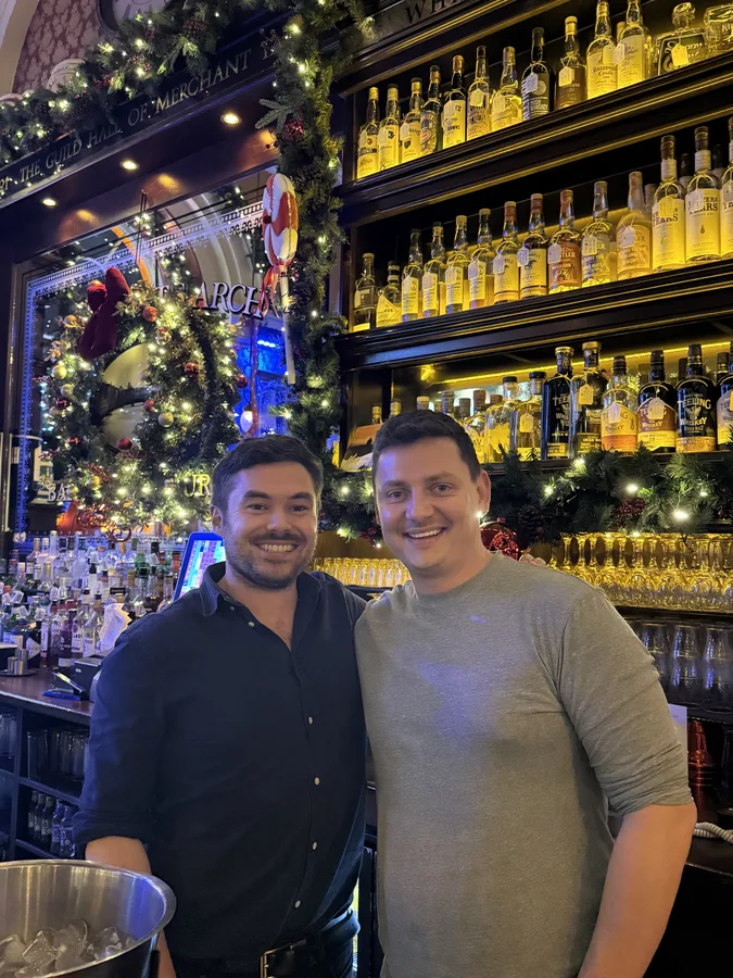 Two team members at a Dublin pub decorated for Christmas