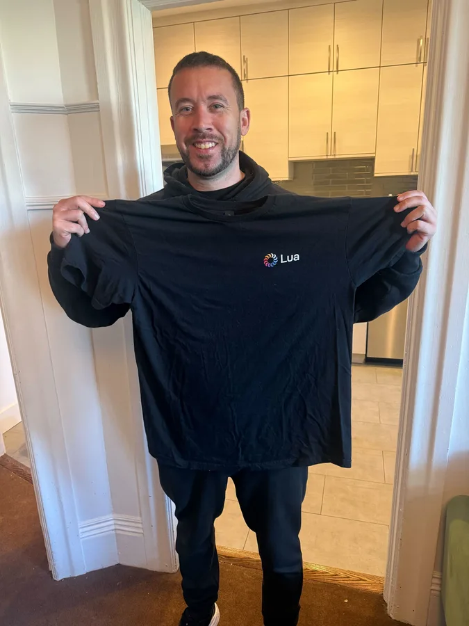 A team member holding up a Lua tee