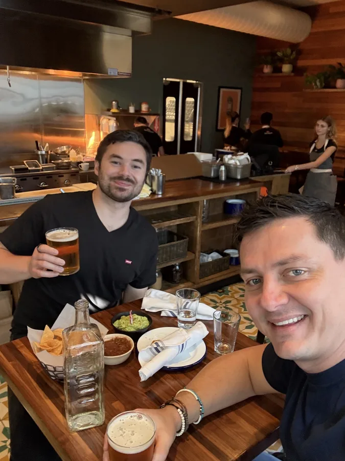 Two founders with beers and guacamole at a taco spot