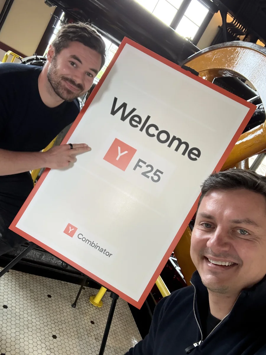 Lorcan and Stefan taking a selfie with the Welcome YC F25 sign